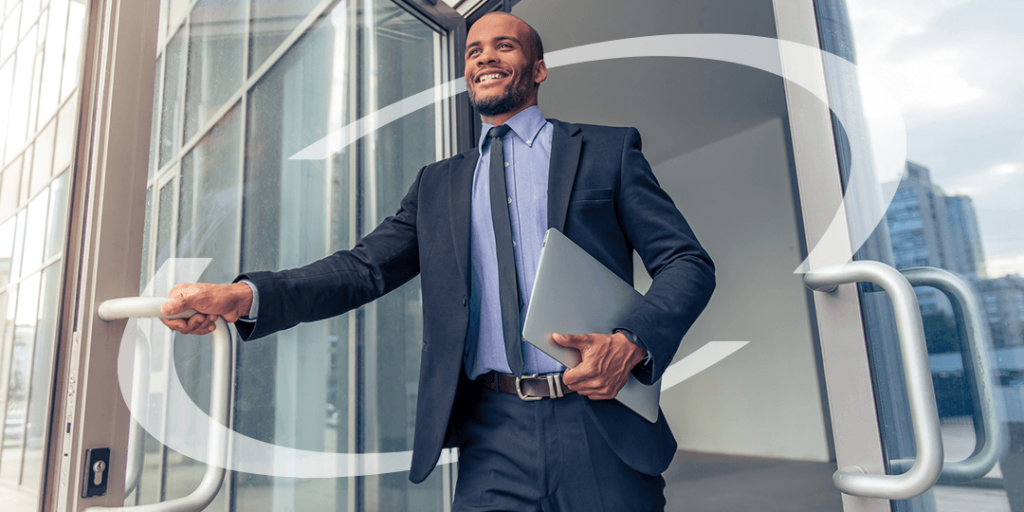 man smiling holding a laptop as a leaves a business