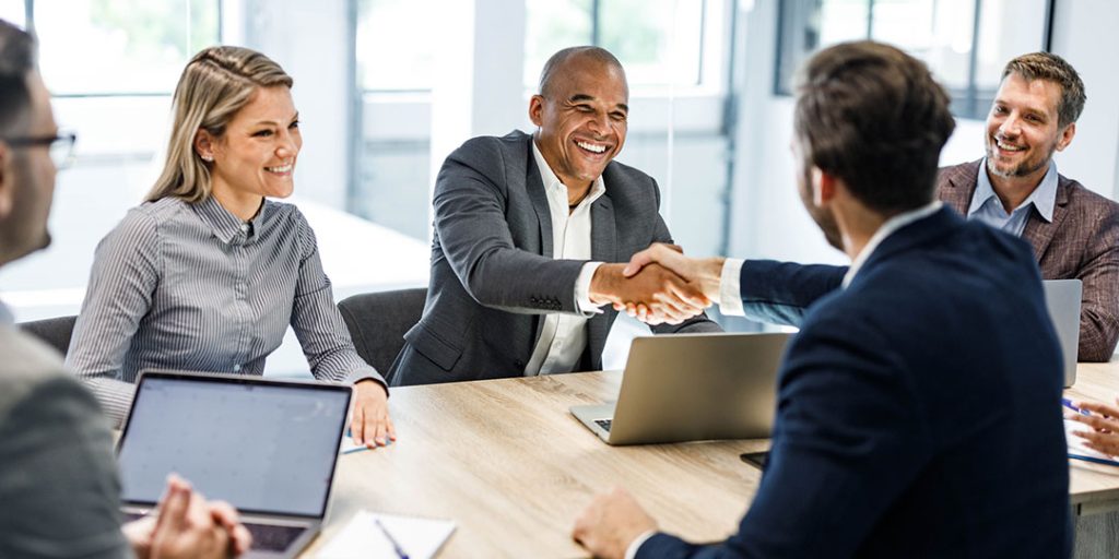 well dressed group shake hands sitting in an office space
