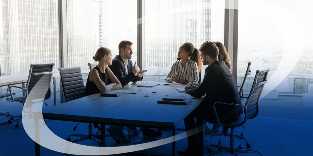 Brokers and business owners sit at a table in an office space