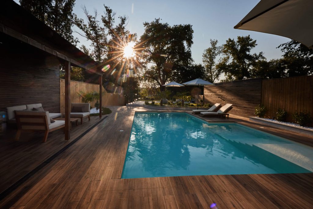 Rectangular Pool and deck with lounge seating and umbrellas