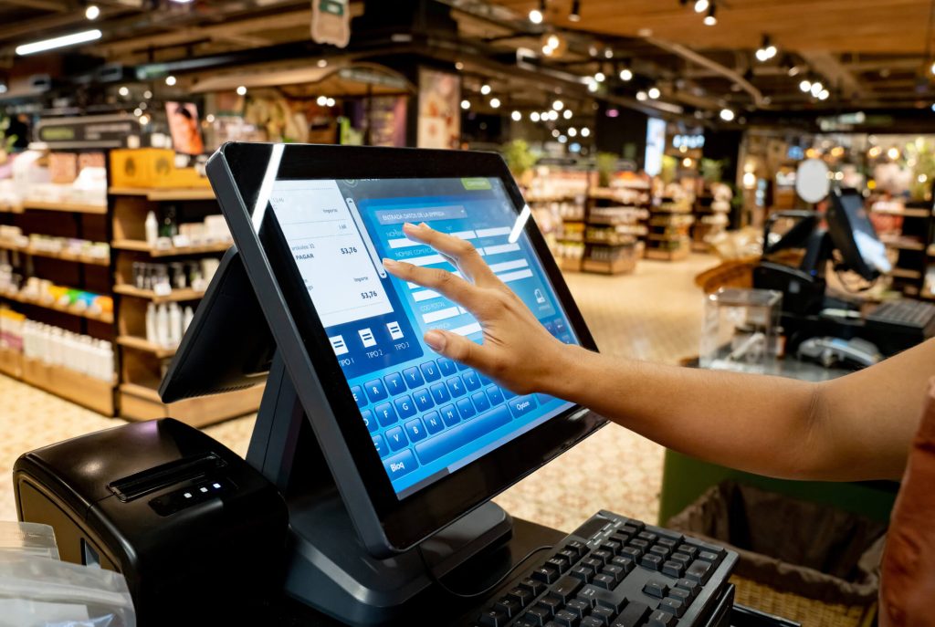 Employee using a Touch screen Point of Sale register in a grocery market