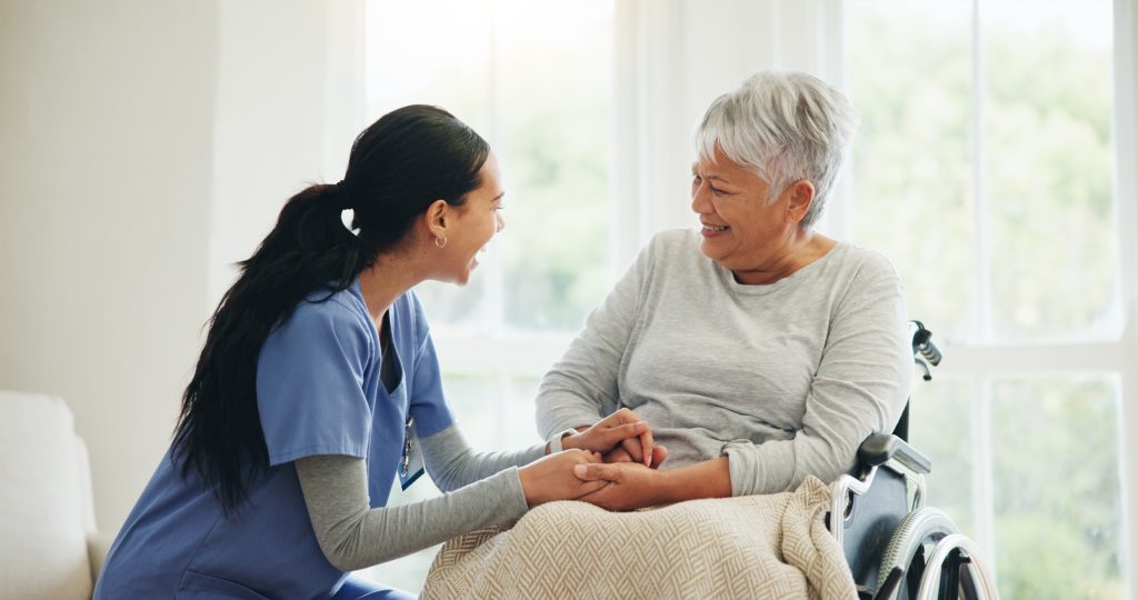 Happy woman, doctor and senior patient in wheelchair, support or trust for healthcare advice at old age home. Medical nurse, caregiver or person with a disability smile for care or help at house