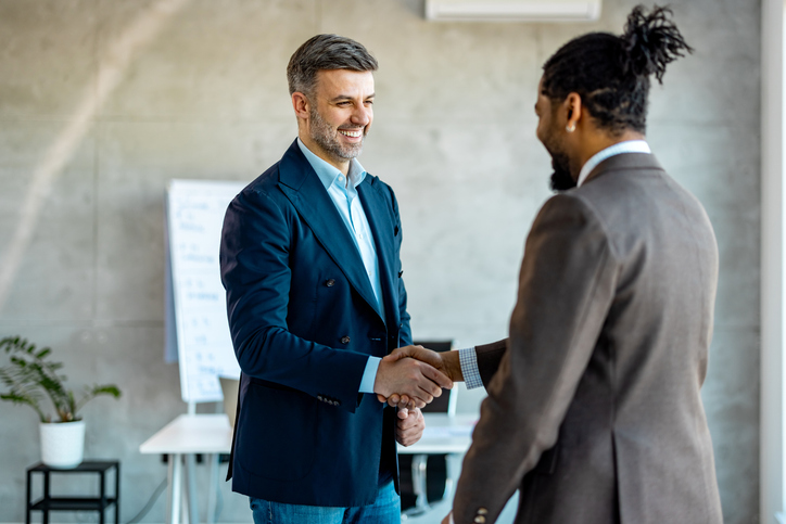 Two businessmen shaking hands in an office