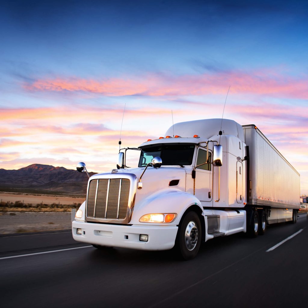 Front of a tractor trailer on the road at dusk