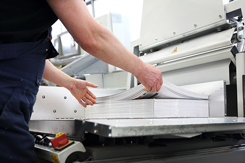 Up Close Shot of a Man using a paper cutter